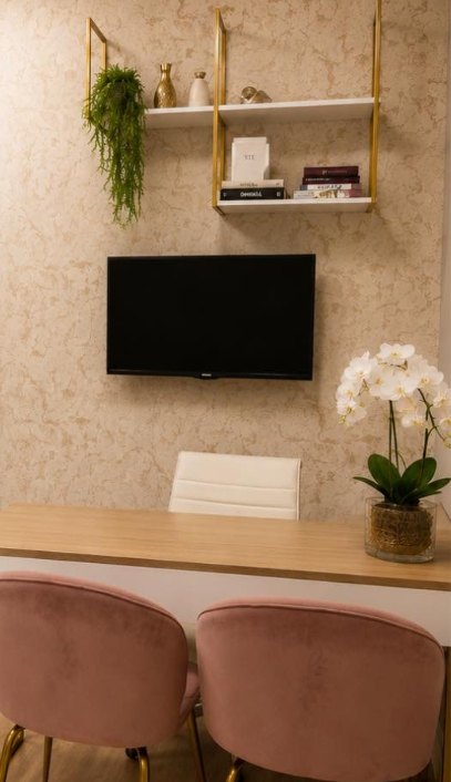 Sala de planejamento da clínica, com mesa, cadeiras e prateleiras douradas